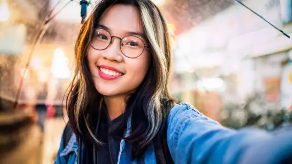 Asian girl taking a selfie in rain.